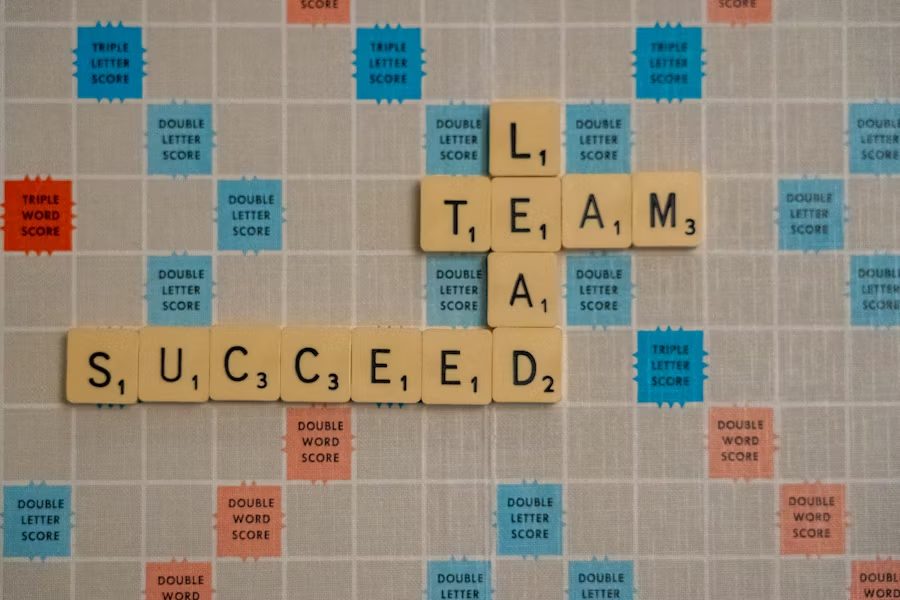 scrabble board: "Lead Team Succeed"